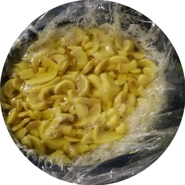 Slice white champignon mushroom in vinegar in drums